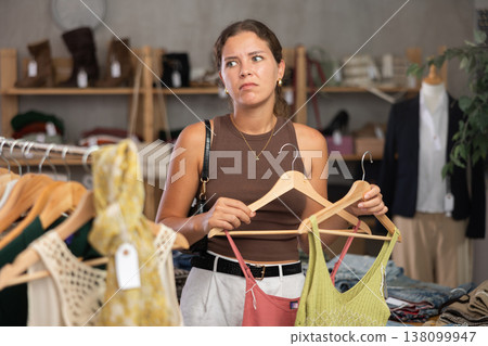 Distressed young woman customer in sales area of clothing store 138099947