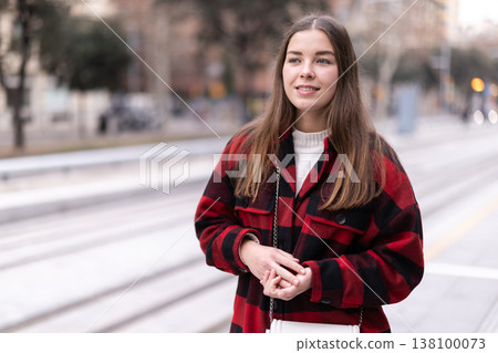 woman stands at a public transport stop woman stands at a public transport stop 138100073