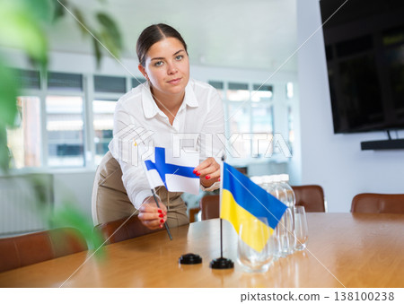 Young lady sets miniatures flags of Ukraine and Finland for international negotiations Young lady sets miniatures flags of Ukraine and Finland for international negotiations 138100238
