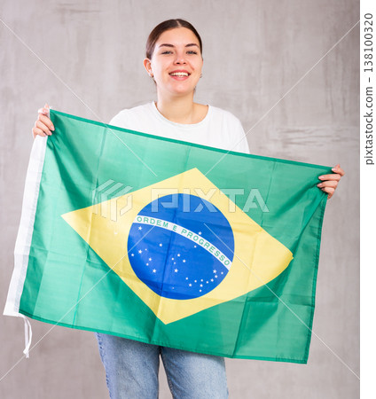 Smiling young woman holding Brazil flag Smiling young woman holding Brazil flag 138100320