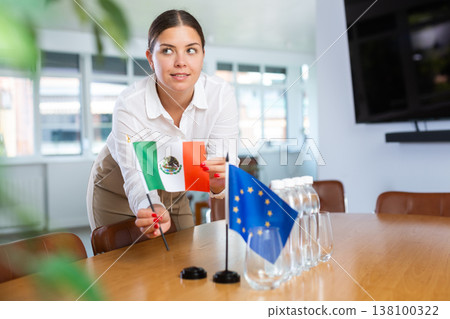 Female secretary places flags of the European Union and Mexico flag on the table before negotiations of top political figures Female secretary places flags of the European Union and Mexico flag on the table before negotiations of top political figures 138100322