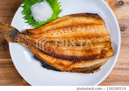 Grilled Atka mackerel with salt, served with grated daikon radish (Japanese style grilled fish), served on a wooden table. Grilled Atka mackerel with salt, served with grated daikon radish (Japanese style grilled fish), served on a wooden table. 138100519