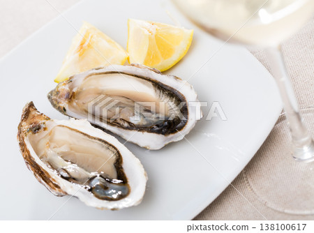 Opened raw oysters with lemon 138100617