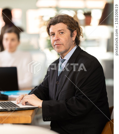 European man working on laptop with room in office 138100619