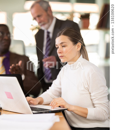 Middle aged woman working in a team in an office 138100620