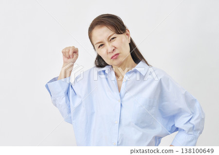 A woman clenching her fists in anger against a white background. A woman clenching her fists in anger against a white background. 138100649
