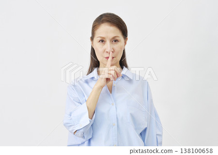 一位女士在白色背景上做出一個神秘的手勢 138100658