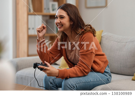 Success, happy and a woman gaming on the sofa with a win, celebration and excited about competition. Smile, house and a girl with a console for a game, entertainment and achievement with technology 138100989