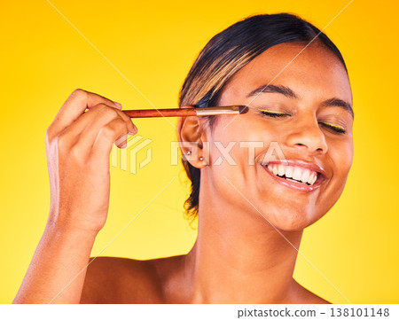 Woman, eye makeup and beauty with face, brush for cosmetology and cosmetic product on yellow background. Happy model, apply powder or foundation with self care, skin glow and eyeshadow in studio 138101148