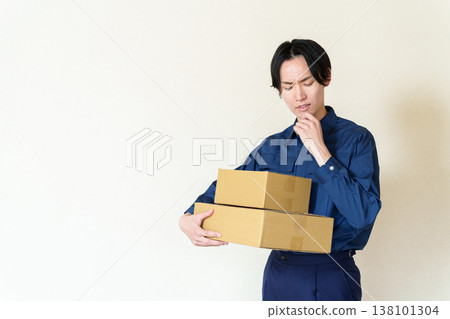 外送員抱著紙箱，陷入沉思。 138101304