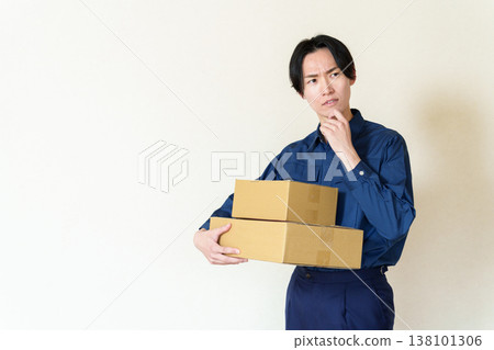 外送員抱著紙箱，陷入沉思。 138101306