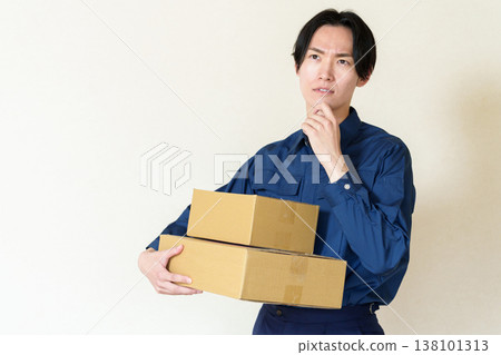 外送員抱著紙箱,陷入沉思。 外送員抱著紙箱,陷入沉思。 138101313
