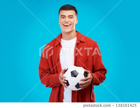 Soccer ball, happy and portrait of man on blue background for sports, winner and achievement. Smile, football fan and person cheer for team success, winning match, game and tournament in studio 138101425