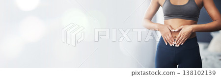 Heart hands, bokeh and stomach of woman with gut health, diet or detox results at gym for wellness or training. Weight loss, abdomen and female athlete at a fitness center with finger frame for care 138102139