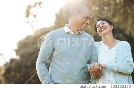 Happy, love and senior couple in a park on an outdoor date for romance, bonding or love. Smile, talking and elderly man and woman in retirement in conversation walking in a field together at sunset. 138102830