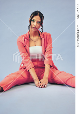 Woman, fashion and portrait of gen z style with cosmetics and sitting in studio. Trendy, stylish suit and relax female person with freedom, cosmetics and modern clothes with blue background 138103382