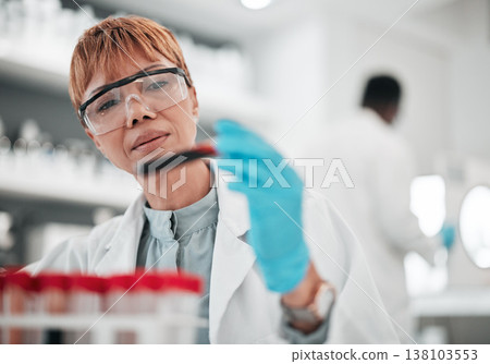 Woman, scientist and blood sample in lab, ideas and analysis with ppe glasses, safety and test. Science, pathology and expert with thinking, inspection and dna data for medical research in laboratory 138103553