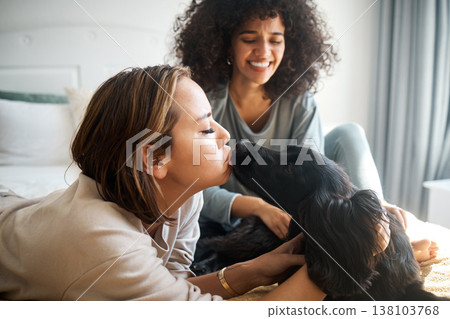 Dog, bed and gay couple kiss in home, morning and relax together in house. Pet, bedroom and happy lesbian women with animal, bonding and having fun in healthy relationship, love connection and care 138103768