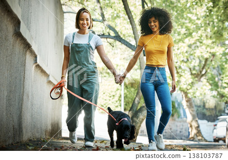 Smile, holding hands and lesbian couple walking with dog in city street for exercise, bonding and fun. Love, animal and interracial young lgbtq women in town road with puppy for fresh air together. Smile, holding hands and lesbian couple walking with dog in city street for exercise, bonding and fun. Love, animal and interracial young lgbtq women in town road with puppy for fresh air together. 138103787