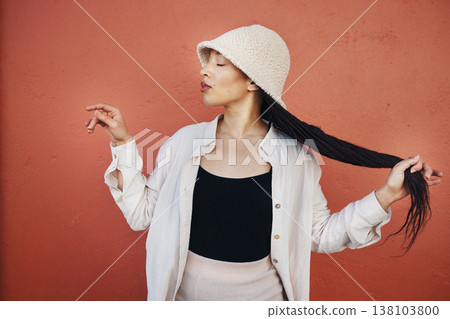 Fashion, hair and African woman orange background with trendy outfit, cool clothes and style for glamour. Beauty, makeup and person by wall with confidence, hairstyle and cosmetics in urban town Fashion, hair and African woman orange background with trendy outfit, cool clothes and style for glamour. Beauty, makeup and person by wall with confidence, hairstyle and cosmetics in urban town 138103800