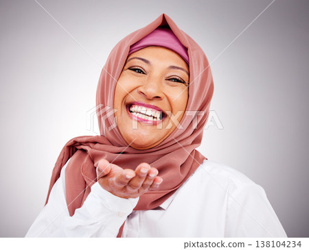 Blow kiss, happy and portrait of Muslim woman in studio with makeup, cosmetics and beauty. Fashion, style and face of Islamic person with hand gesture for love, affection or emoji on gray background 138104234