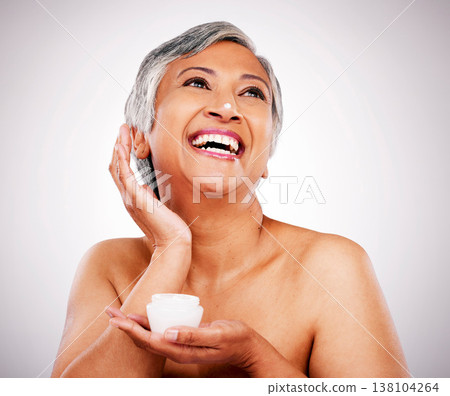Face cream, skin and beauty of a mature woman with natural glow on a white background. Dermatology, moisturizer and cosmetics of aesthetic model for facial shine, wellness or self care in studio 138104264