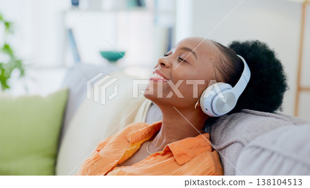 Calm woman, music and headphones in home for listening to audio, radio and hearing podcast on sofa. Happy african person relax for streaming sound, multimedia and peaceful subscription in living room Calm woman, music and headphones in home for listening to audio, radio and hearing podcast on sofa. Happy african person relax for streaming sound, multimedia and peaceful subscription in living room 138104513