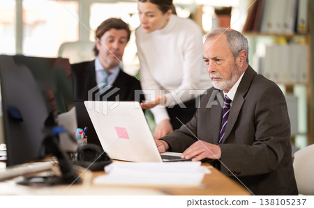 Mature man working in a team in an office Mature man working in a team in an office 138105237