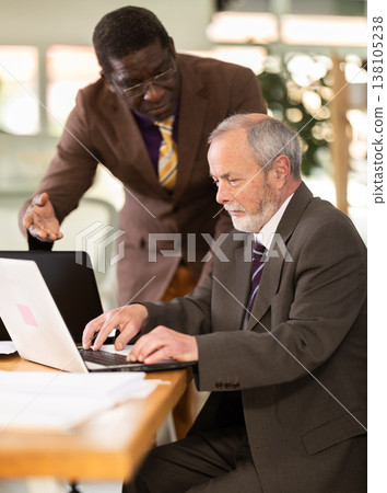 Boss gives instructions to employees while they work in company office Boss gives instructions to employees while they work in company office 138105238