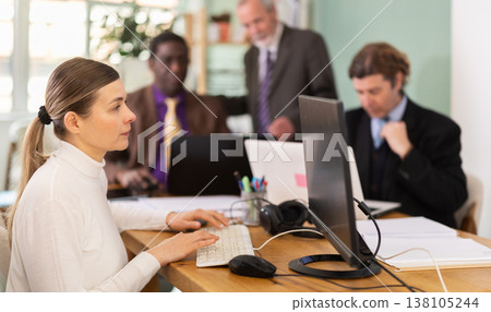 Middle aged woman working in a team in an office Middle aged woman working in a team in an office 138105244