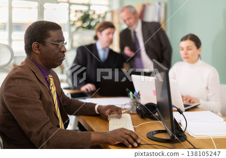 African man working in office with team 138105247
