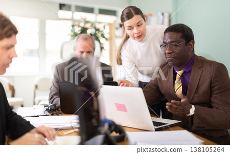 Female manager helping to man during working at laptop in office Female manager helping to man during working at laptop in office 138105264