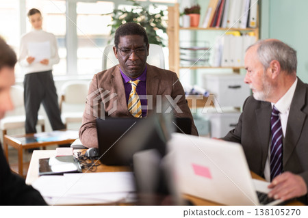African man working in office with team African man working in office with team 138105270