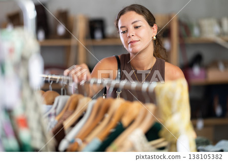 Young woman comes to boutique and looks at clothes 138105382