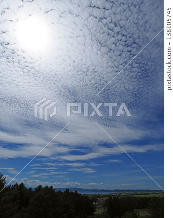 At the end of summer, a bright white sun and cirrocumulus clouds appeared in the sky above Lake Inawashiro. It was a striking and beautiful sight against the blue sky. 138105745
