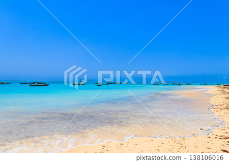 View of tropical sandy Nungwi beach and traditional wooden dhow boats in the Indian ocean on Zanzibar, Tanzania 138106016