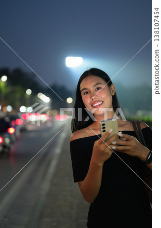 Thai Woman Ordering Taxi with Smartphone in Hanoi Thai Woman Ordering Taxi with Smartphone in Hanoi 138107454