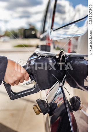 Fueling car at gas station closeup with hand holding nozzle Fueling car at gas station closeup with hand holding nozzle 138107806