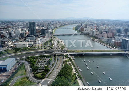 An aerial view of the cityscape of Niigata and the flow of the Shinano River, looking towards the Bandai Bridge. 138108298
