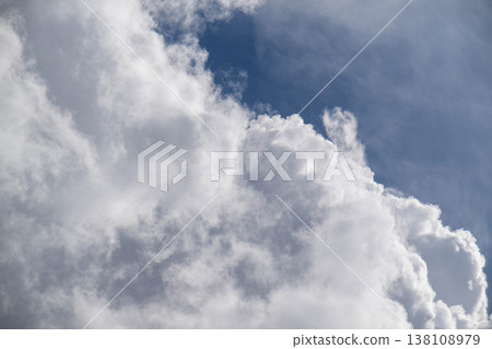 Dramatic sky scene featuring voluminous clouds against a vibrant blue background Dramatic sky scene featuring voluminous clouds against a vibrant blue background 138108979