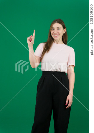 Pretty young woman showing peace gesture different emotions of a young girl on a green background chromakey beautiful facial features real people pink T-shirt white skinned European. black flared wide Pretty young woman showing peace gesture different emotions of a young girl on a green background chromakey beautiful facial features real people pink T-shirt white skinned European. black flared wide 138109160