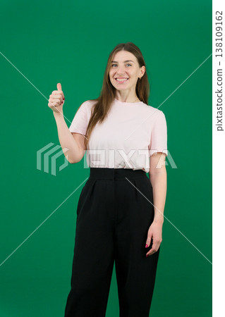 Pretty young woman showing peace gesture different emotions of a young girl on a green background chromakey beautiful facial features real people pink T-shirt white skinned European. black flared wide Pretty young woman showing peace gesture different emotions of a young girl on a green background chromakey beautiful facial features real people pink T-shirt white skinned European. black flared wide 138109162