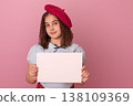 Young Girl Posing in a Pink Studio Holding a Blank Sign and Wearing a Stylish Beret 138109369
