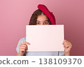 Young Girl in a Beret Holding a Blank Sheet of Paper Against a Solid Pink Background 138109370