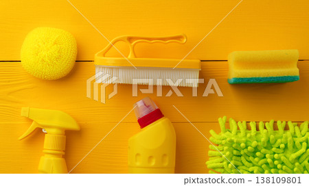 Cleaning tools arranged on a bright yellow surface for household tasks and chores 138109801