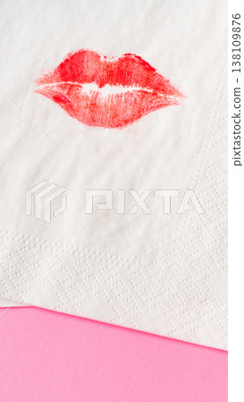 Kiss mark on a napkin resting on a pink surface during a party or gathering 138109876