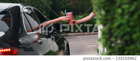 Hand Man in car receiving coffee in drive thru fast food restaurant.  138109962