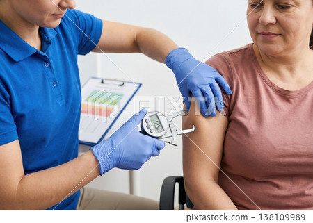 Health Professional Measuring Body Fat Percentage with Caliper on Patient in Medical Setting 138109989