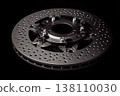 Close-up of high-performance drilled brake disc on black background 138110030