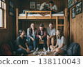 Group of young adults relaxing and playing cards in cozy wooden cabin room 138110043